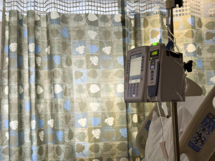 Empty hospital bed in patient room with medical equipment