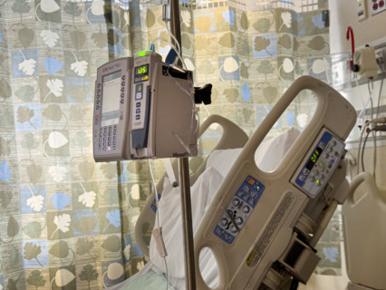 Empty hospital bed in patient room with medical equipment