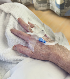 Hospital patient with IV port inserted in his hand