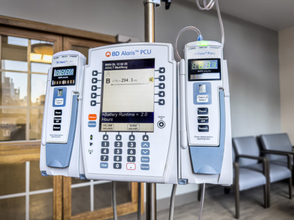 BD Alaris PCU IV pump machine in hospital room