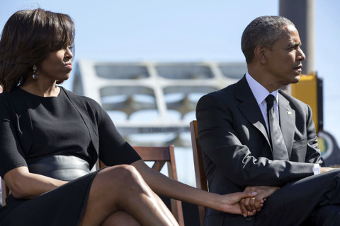 U.S. President Barack Obama and U.S. First Lady Michelle Obama holding hands as they listen to U.S.