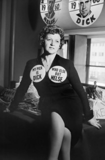 Woman seated on table, wearing Republican Party buttons supporting Richard Nixon and Nelson