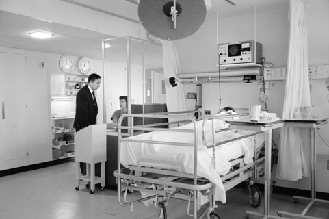 Patient in bed and staff in hospital room, Morris Cafritz Memorial Hospital, Washington, D.C., USA,