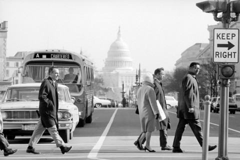 Pedestrians crossing Pennsylvania Avenue with view of U.S. Capitol Building in background,