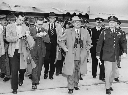 U.S. President Harry S. Truman (center, with binoculars) is followed by unknown reporters while