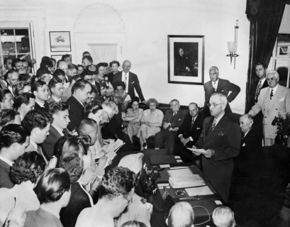 U.S. President Harry S. Truman (standing at desk) announcing surrender of Japan to assembled