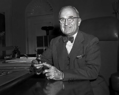 U.S. President Harry S. Truman sitting at his desk with paperweight, a gift to him from a 4-H
