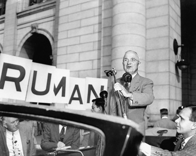 U.S. President Harry S. Truman speaking to crowd from open car upon his return from political trip