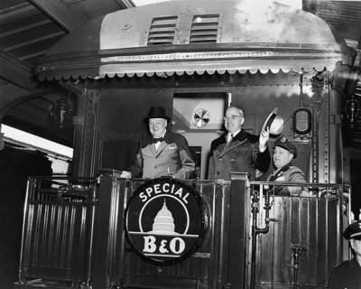 U.S. President Harry S. Truman (right) waving his hat standing to right of former British Prime