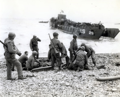 American soldiers applying artificial respiration on two other soldiers who reached the north coast