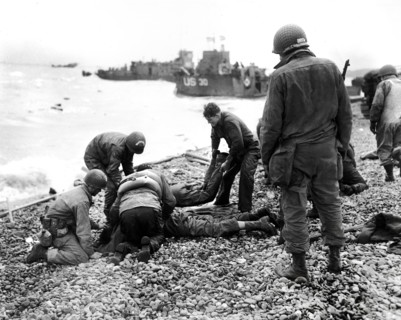 American soldiers applying artificial respiration on two other soldiers who reached the north coast
