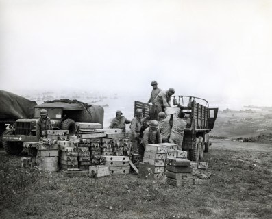 American members of 616th Ordnance Company load ammunition for the famed German 88 gun onto a truck