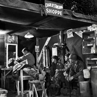 American soldiers wait their turn at Charlie's Tonsorial Shoppe, Normandy, France, U.S. Army Signal
