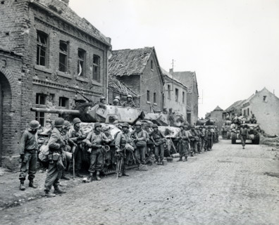 Infantrymen of 1st Division, U.S. First Army, resting beside military tanks, Monchengladbach, North