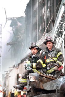 Two firefighters look on during U.S. President George W. Bush's visit to World Trade Center