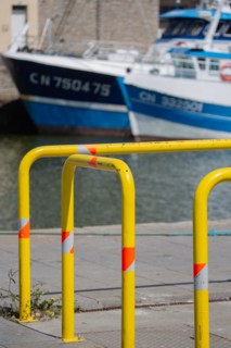 Port en Bessin Huppain, quay with yellow barriers and moored trawlers