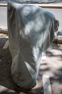Motorbike under a tarpaulin, in Paris