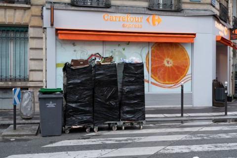 Paris, magasin d’alimentation et poubelles sorties