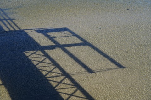 Shadow cast of a footbridge on the sand