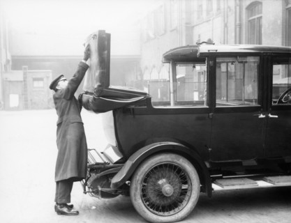 Chauffeur with a partly convertible Daimler. Artist: Unknown