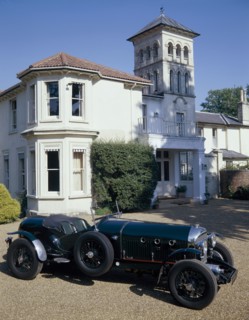 A 1930 Bentley Supercharged outside a house. Artist: Unknown