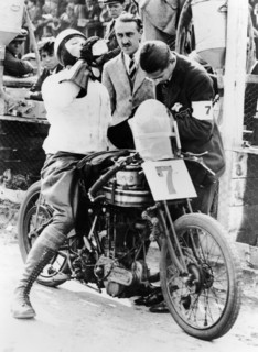 Van Horne taking a drink whilst on his Norton bike. Artist: Unknown