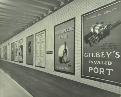 Advertisements for beer and port, Holborn Underground Tram Station, London, 1931. Artist: Unknown.