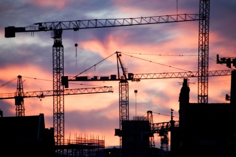 A building site at sunset with cranes silhouetted against a red sky, 2007