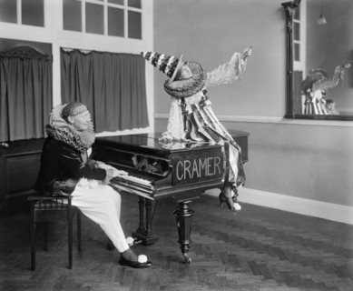 Two Pierrot clowns performing a routine with a piano, 1917
