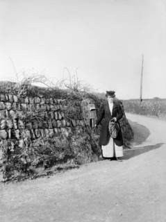 Postwoman emptying a postbox at an unidentified location in Kerrier, Cornwall, 1901