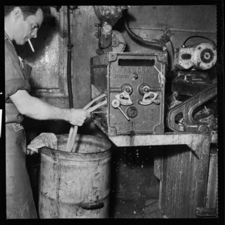 Man smoking whilst operating an Ernest A Bitterling Ltd stripper crusher machine, 1966-1974