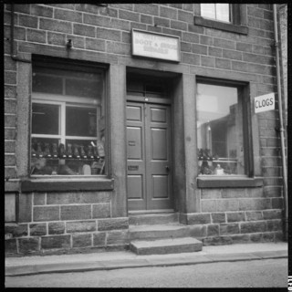 Clogs displayed in the window of H Greenwood Boot & Shoe Repairs shop, 1966-1974