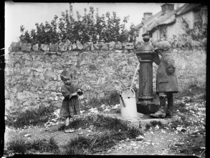 Two children collecting water at a water pump, Cheddar, Somerset, 1907