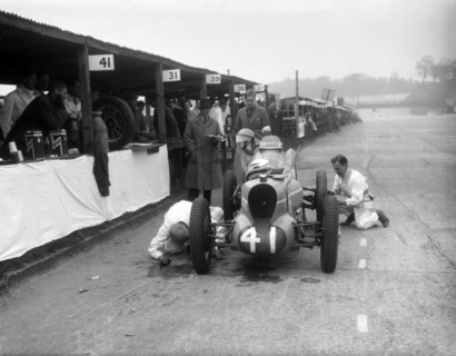 Mechanics working on the MG of Doreen Evans, JCC International Trophy, Brooklands, 1936. Artist: Bill Brunell.
