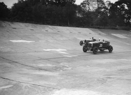 GL Baker's 5954 cc Minerva racing a 1930 Frazer-Nash Sportop on the banking at Brooklands. Artist: Bill Brunell.