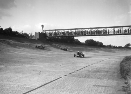 Cars racing on Byfleet Banking during the BRDC 500 Mile Race, Brooklands, 3 October 1931. Artist: Bill Brunell.