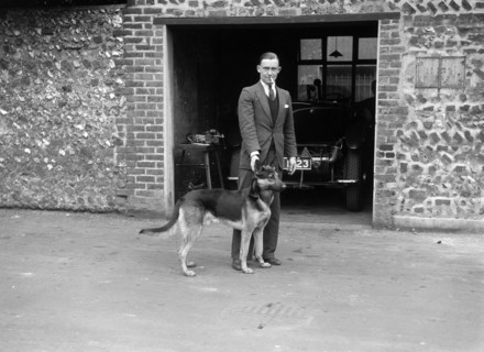 Geoffrey Baker and his alsatian. Artist: Bill Brunell.