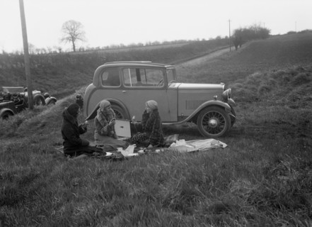 Three women having a picnic during a road test of a Triumph Scorpion, 1931. Artist: Bill Brunell.