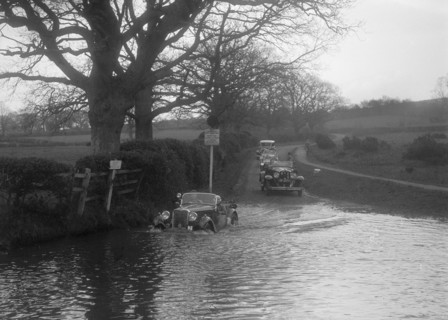 972 cc Singer Le Mans driving through water during a motoring trial, 1936. Artist: Bill Brunell.