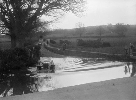 MG Magnette driving through a ford during a motoring trial, 1936. Artist: Bill Brunell.