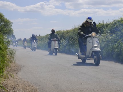 Scooters enjoying run on country lane. Artist: Unknown.