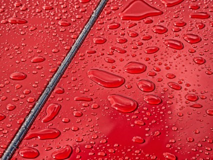 Raindrops beading on classic car paintwork