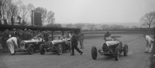 Alfa Romeo and two Bugatti Type 35s on the start line, Donington Park, Leicestershire, 1935. Artist: Bill Brunell.
