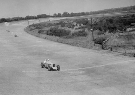 RJ Munday's Munday Special on Byfleet Banking, BARC meeting, Brooklands, Surrey, 1933. Artist: Bill Brunell.