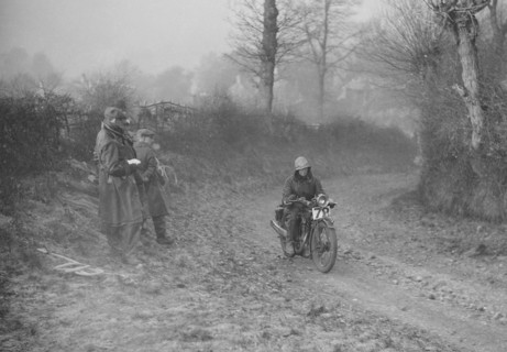 Woman riding a Royal Enfield motorcycle in the Gloucester Trial, c1930s. Artist: Bill Brunell.