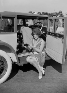 Paddy Naismith pouring a drink from the cocktail bar in her Ballot at the Southport Rally, 1928. Artist: Bill Brunell.