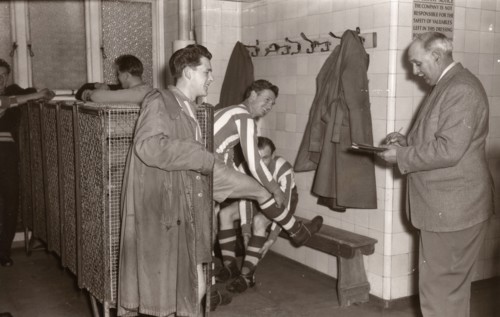 Footballers adjust their boots in the locker room, 1953. Artist: Unknown