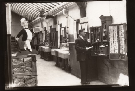 A man uses the clocking in machine, Rowntree factory, Yorkshire, 1929. Artist: Unknown