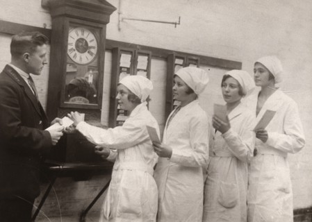Girls queue at the Clocking-In machine, Rowntree factory, York, Yorkshire, 1933. Artist: Unknown