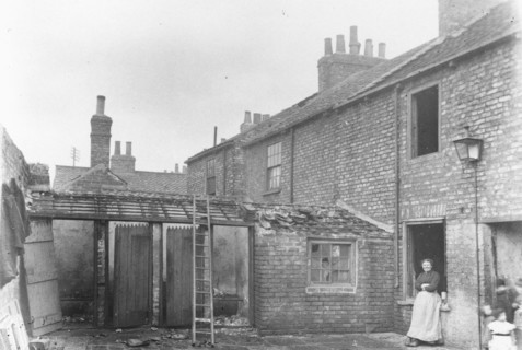 A woman stands in the back yard of a house, York, Yorkshire, 1923. Artist: Unknown